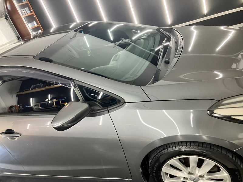 Kia Cerato with a flawless deep gloss finish after calcium and contaminant removal, reflecting light in a professional detailing workshop on the Gold Coast.